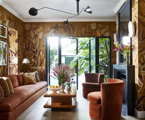 art deco inspired wallpaper headlines a warm earthen palette in a poolside sitting room off the kitchen